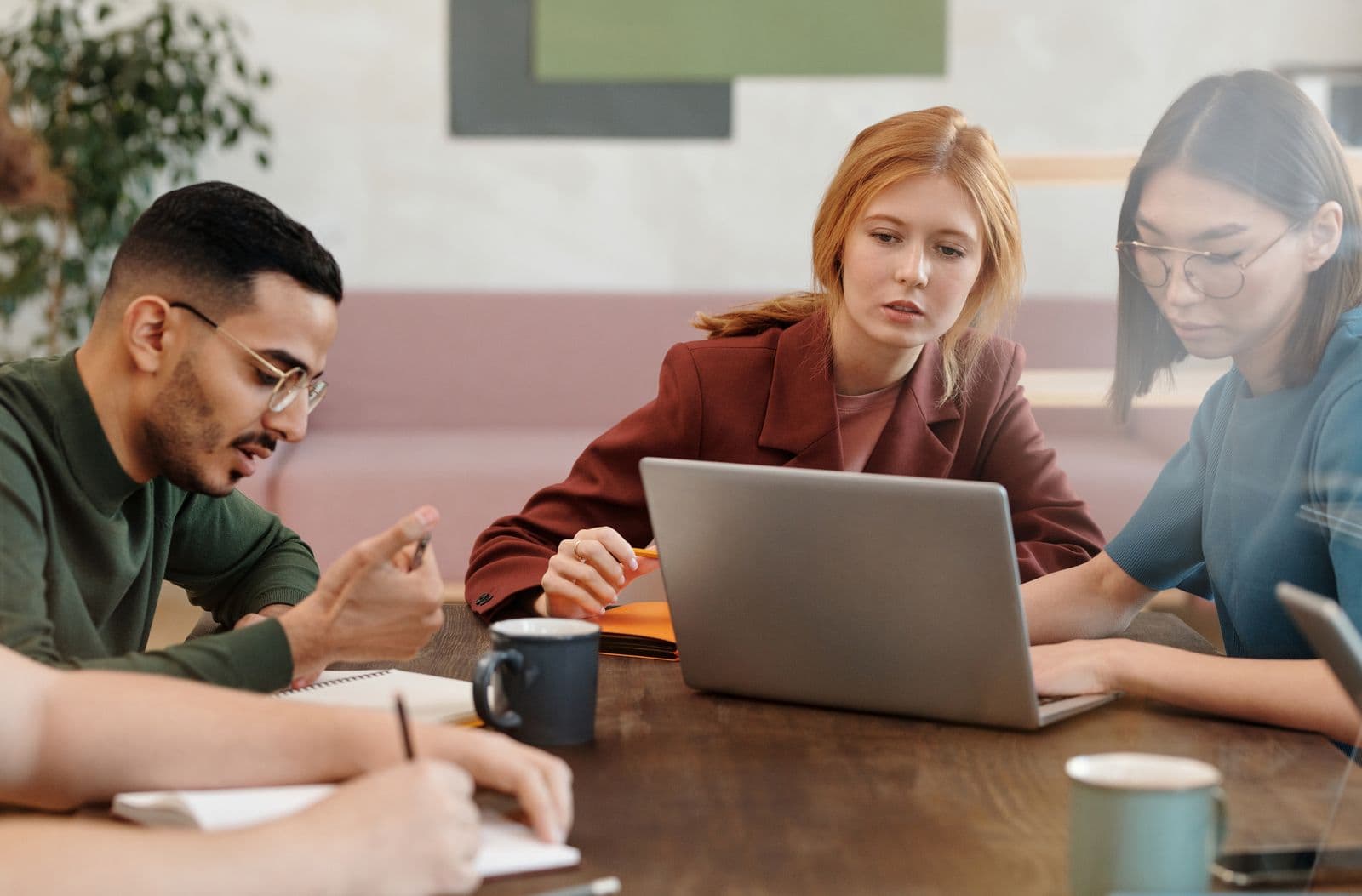 Equipe trabalhando junta em uma mesa com laptop